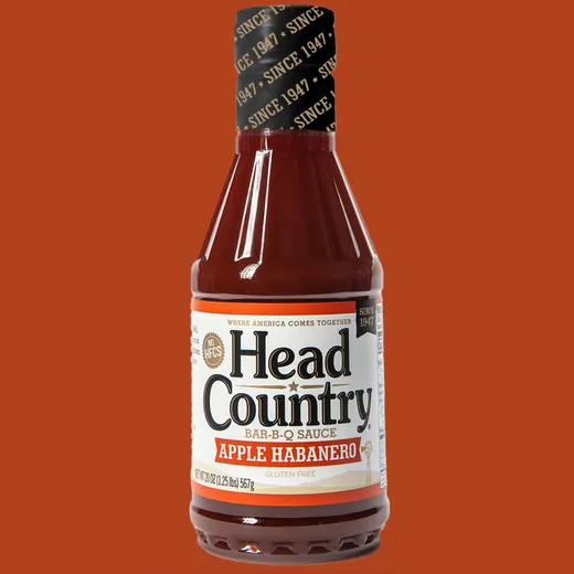A bottle of Head Country Apple Habanero BBQ sauce stands against a plain background.