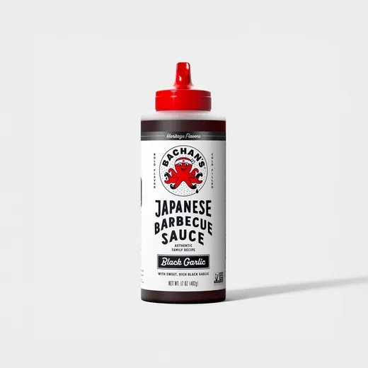 A close-up studio shot of a bottle of Bachan's Black Garlic Japanese Barbecue Sauce.
