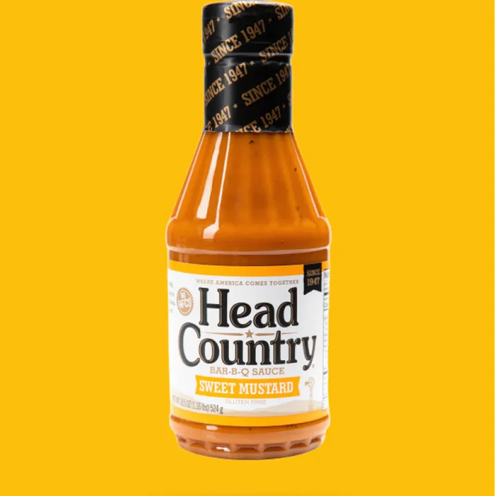 A bottle of Head Country Sweet Mustard barbecue sauce on a yellow background.