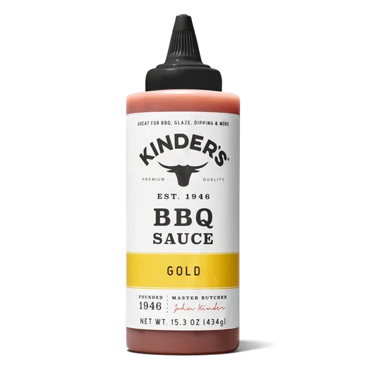 A bottle of Kinder's Gold BBQ sauce on a black background.