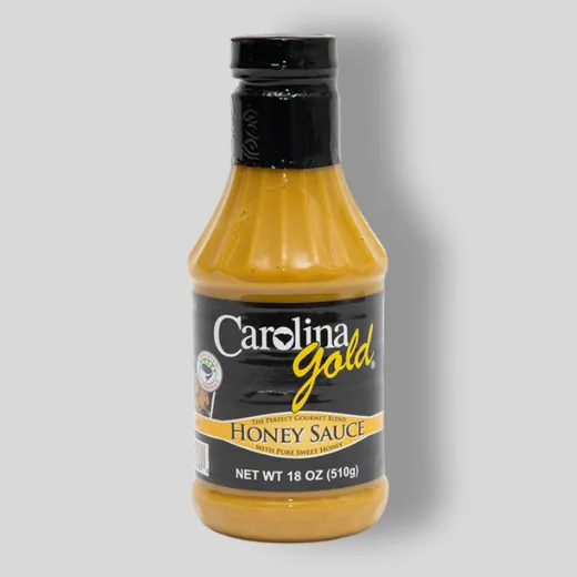 A bottle of Carolina Gold Honey Sauce standing on a plain background.