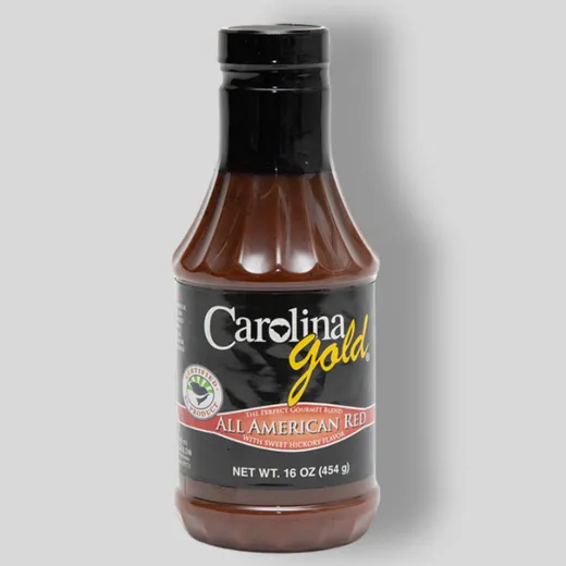 A single 16oz bottle of Carolina Gold All American Red BBQ sauce on a plain background.