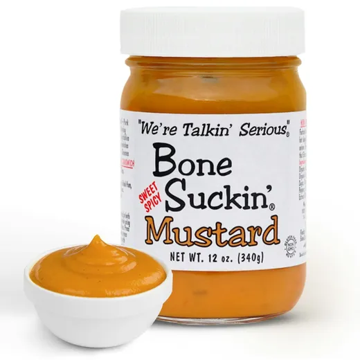 A jar of Bone Suckin' Mustard beside a white bowl filled with serving-sized mustard.
