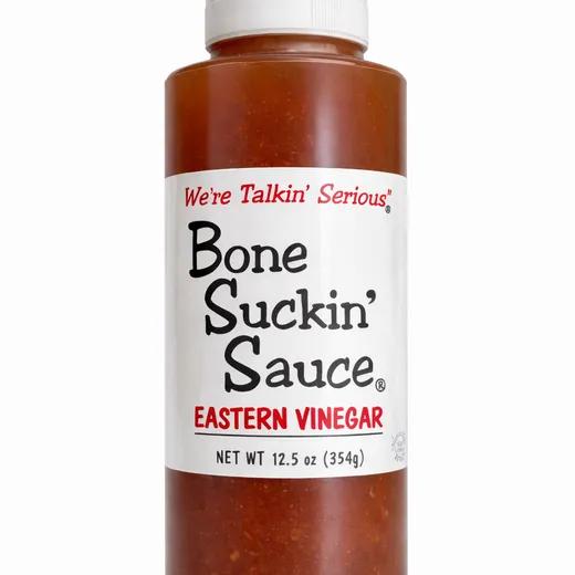 A bottle of Bone Suckin' Sauce Eastern Vinegar with the front label visible.